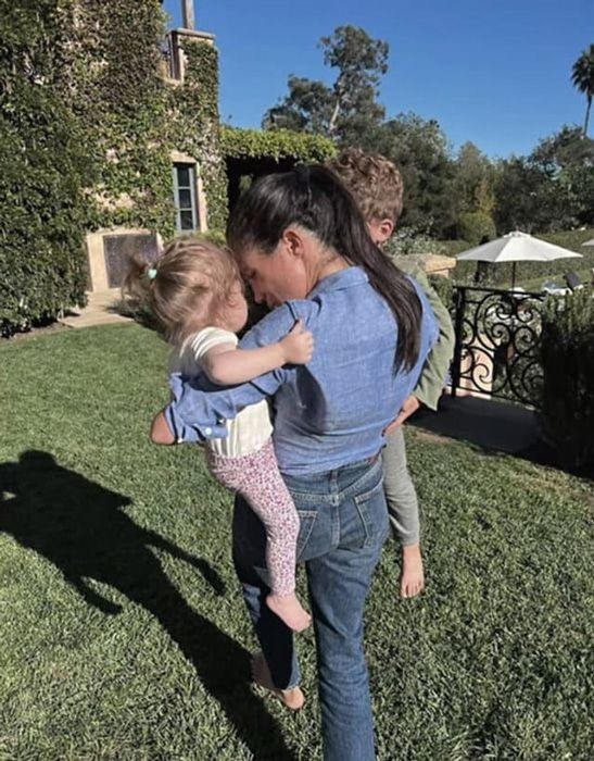 Meghan Markle holding two kids