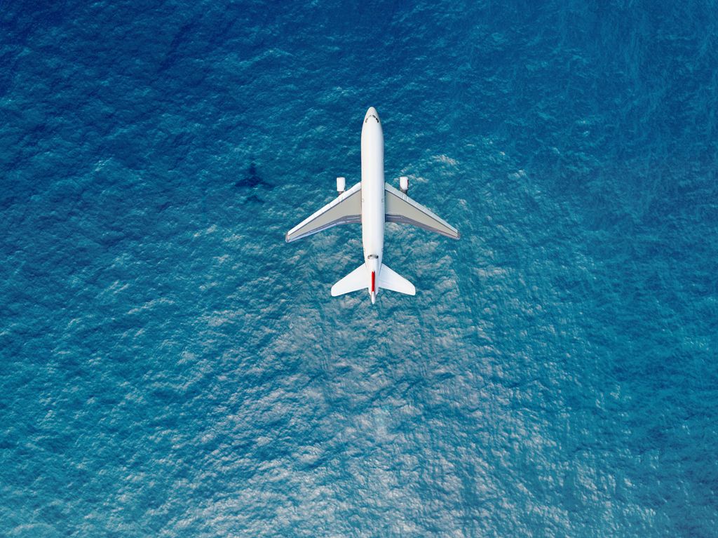 Airplane flies over a sea