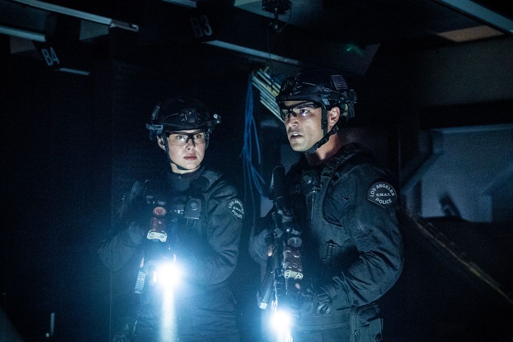 Anna Enger Ritch as Zoe Powell and Niko Pepaj as Miguel Alfaro stand in the dark in uniform in SWAT series finale