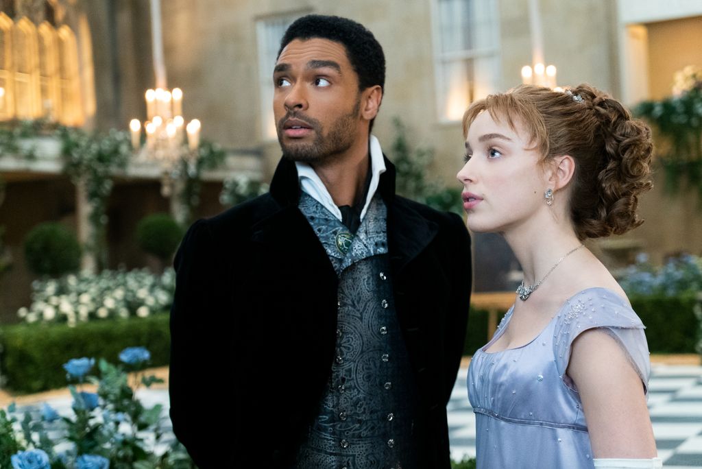 Two people in period clothing in ballroom