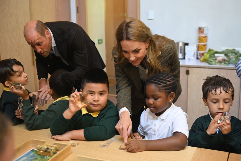 Kate and william looking at nature slides with group of kids