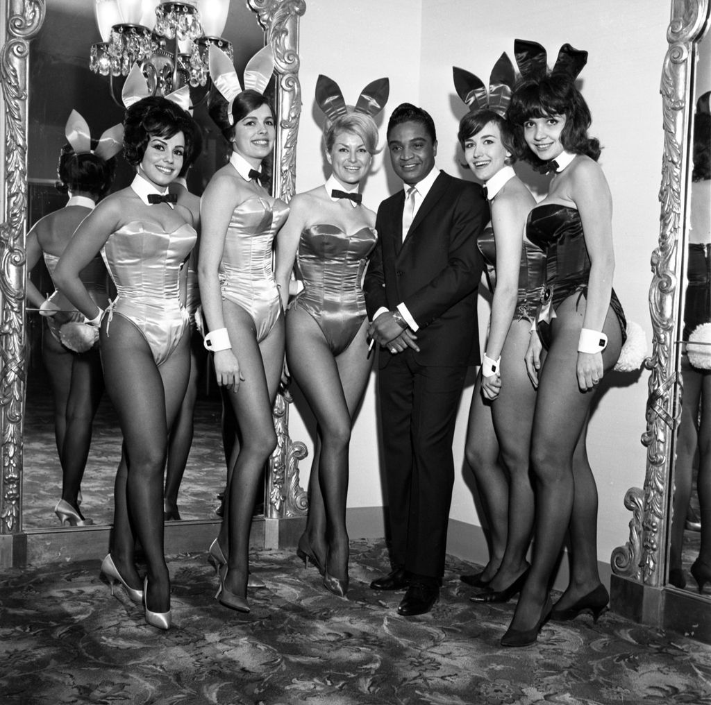 Rock and roll singer Jackie Wilson poses for a portrait with a group of Playboy Bunnies in 1962