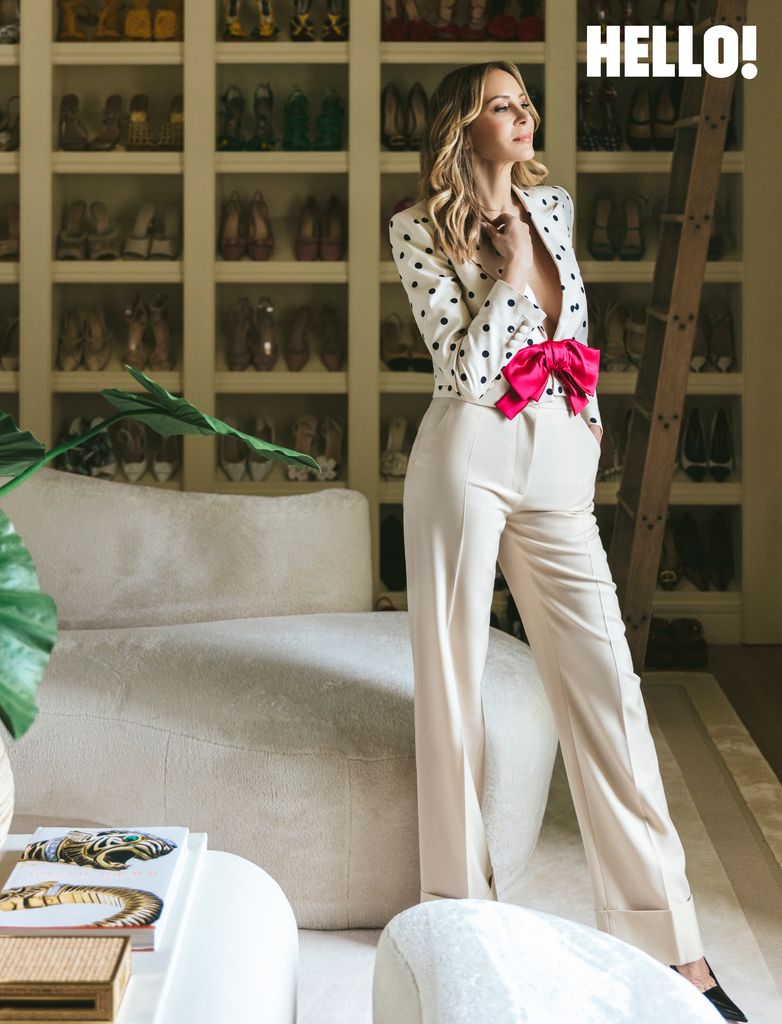 Dee posing in front of her shoe collection