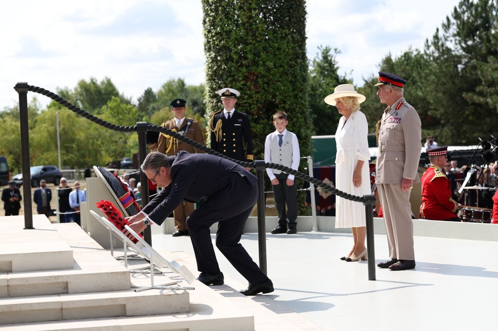 Britain's King Charles III (R) and Britain's Queen Camilla (2R) stand by as Britain's Prime Minister Keir Starmer (L) lays a wreath