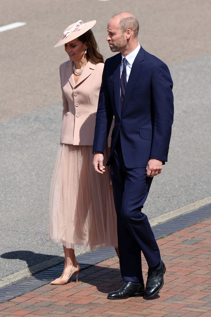 Kate dengan pakaian pink lembut di samping William yang mengenakan setelan jas