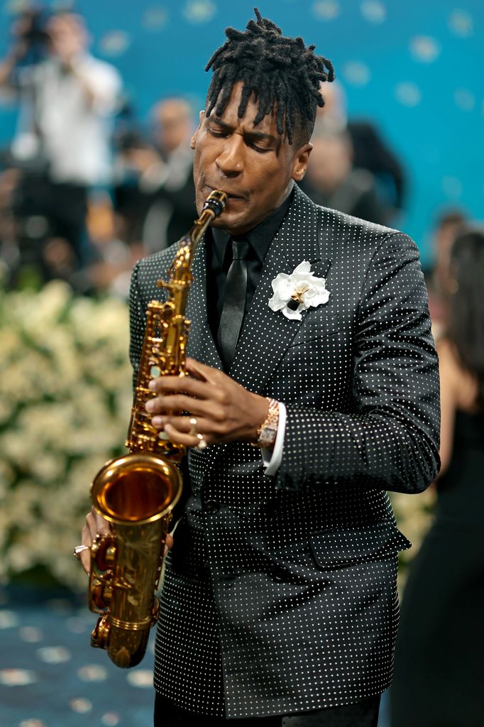 jon batiste playing saxophone on carpet at 2025 met gala