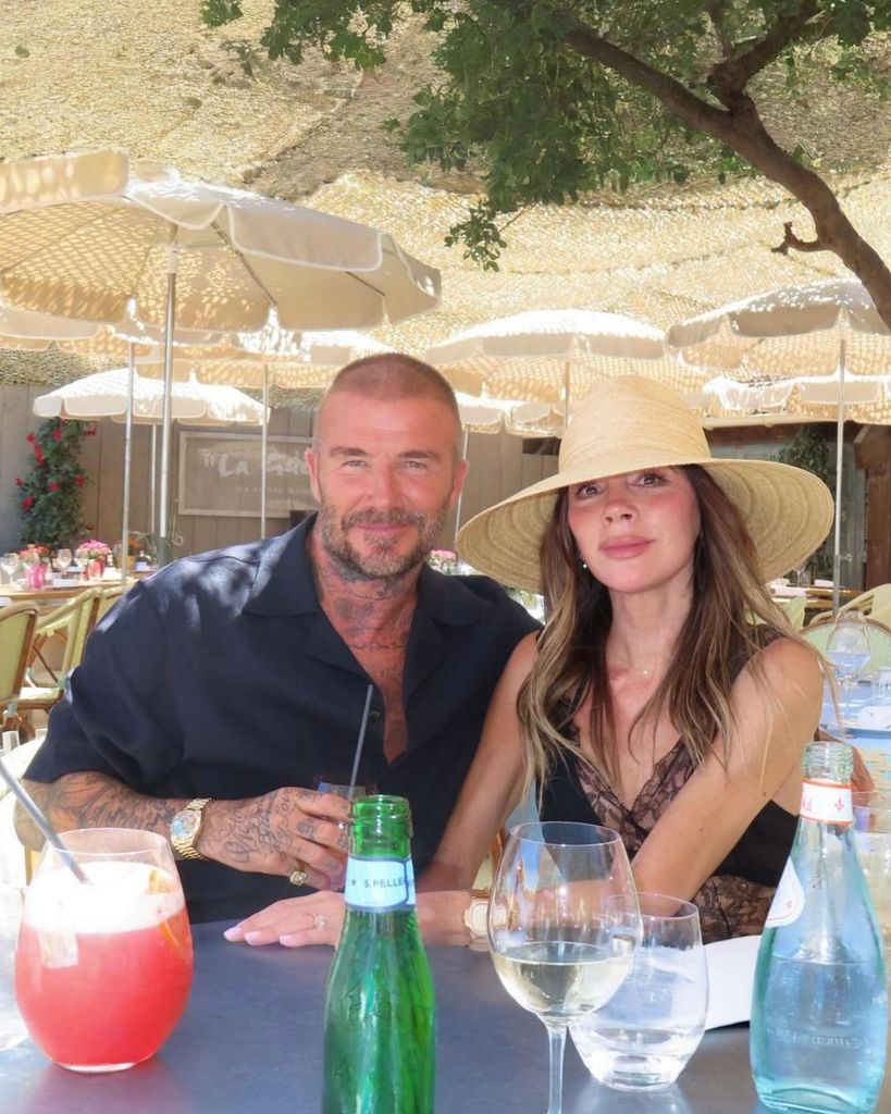 Victoria in a black lace dress at table with david