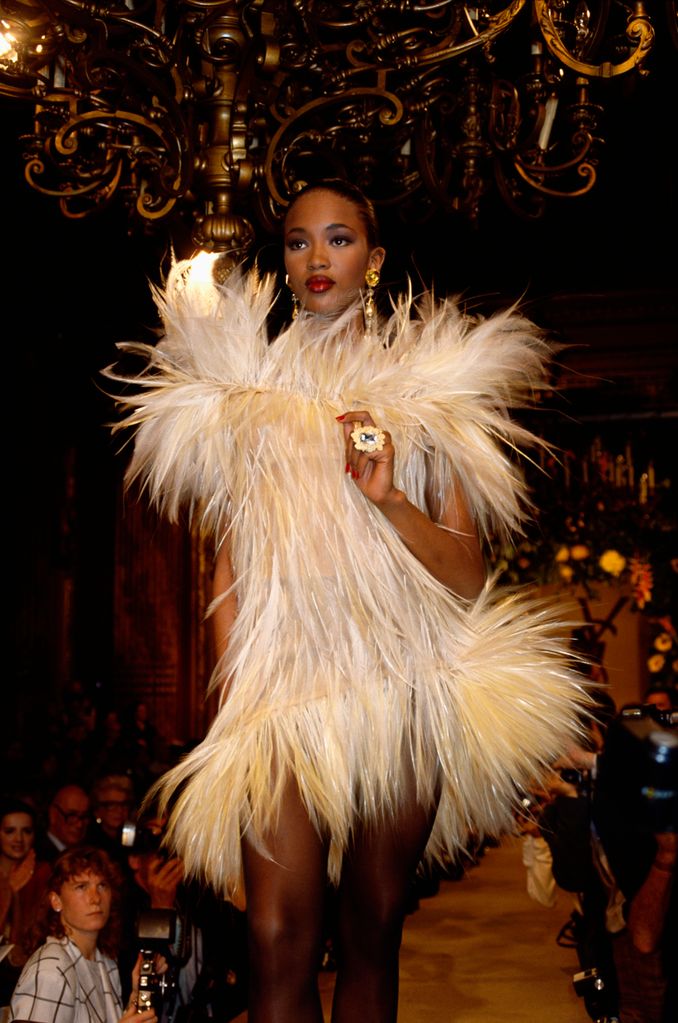 Naomi Campbell wearing a feathered Yves Saint Laurent cocktail dress on the runway 