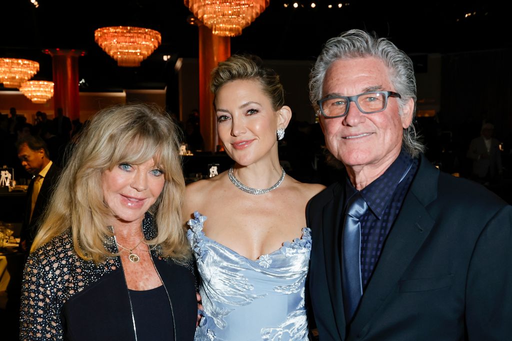 kate hudson in blue dress, kurt russell in suit, and goldie hawn in black dress