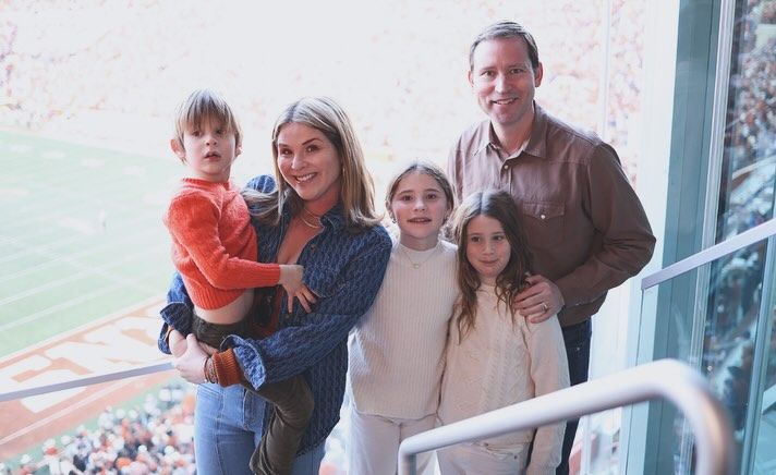 Jenna Bush Hager carrying her son and posing with daughters and husband at a football game