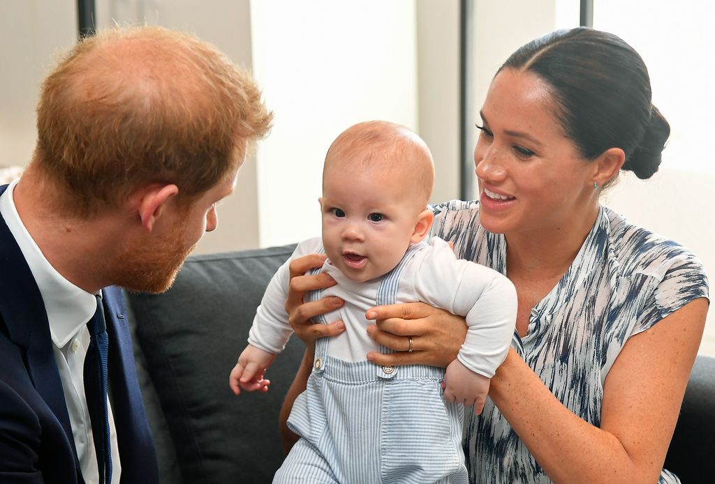 Prince Archie is held by mother Meghan Markle as his dad Prince Harry looks on