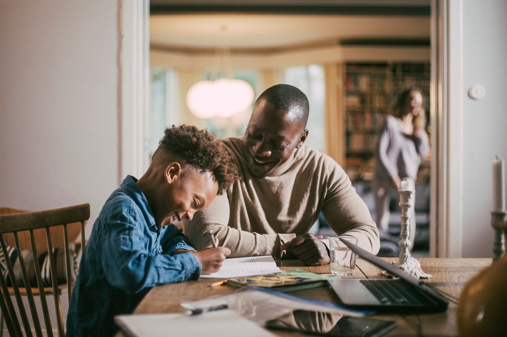 son and father doing homework