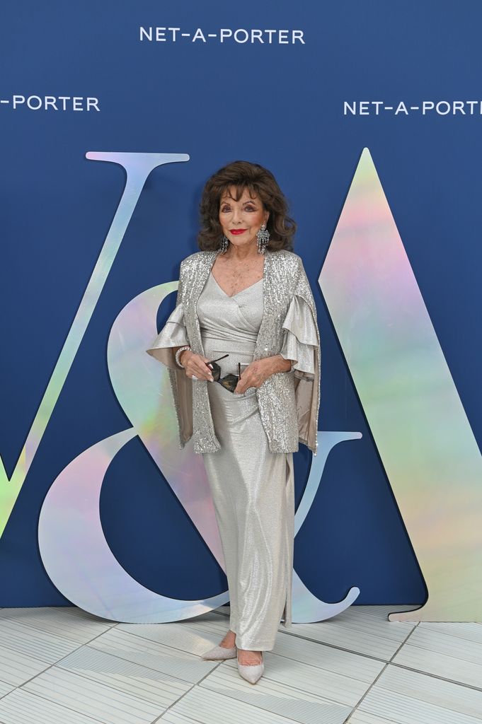 Dame Joan Collins smiling in silver dress