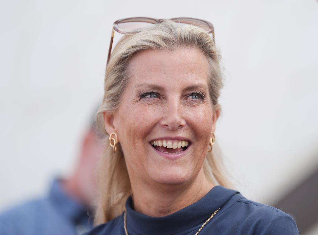 The Duchess of Edinburgh in navy dress shoulders up smiling