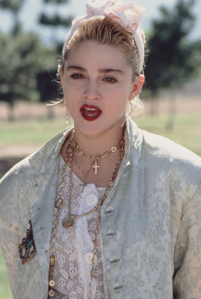 Madonna wearing a headband with red lips and layered necklaces 