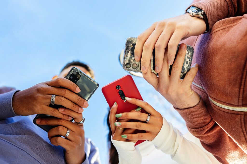 Young people using mobile phones outdoors
