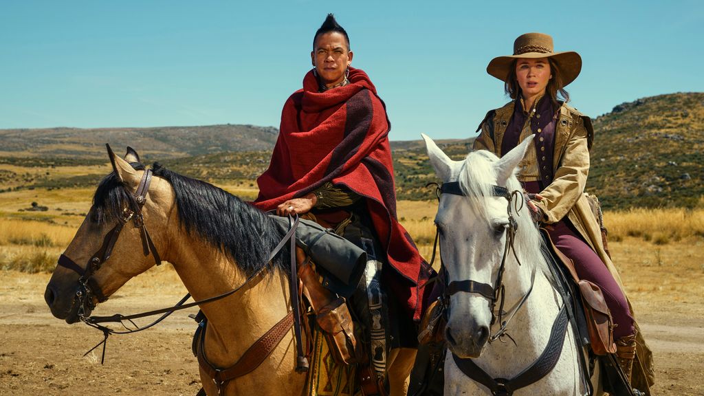 Two people on horses with one wearing a cowboy hat