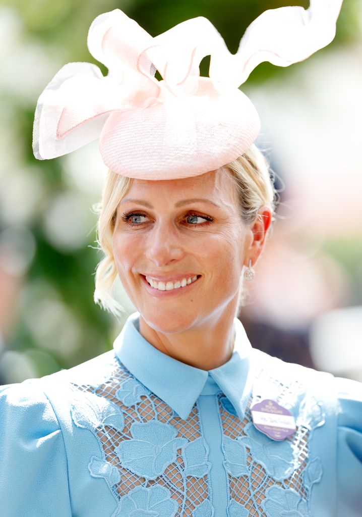   Zara Tindall Smiling Shoulders Up dengan Gaun Biru Dan Topi Merah Muda