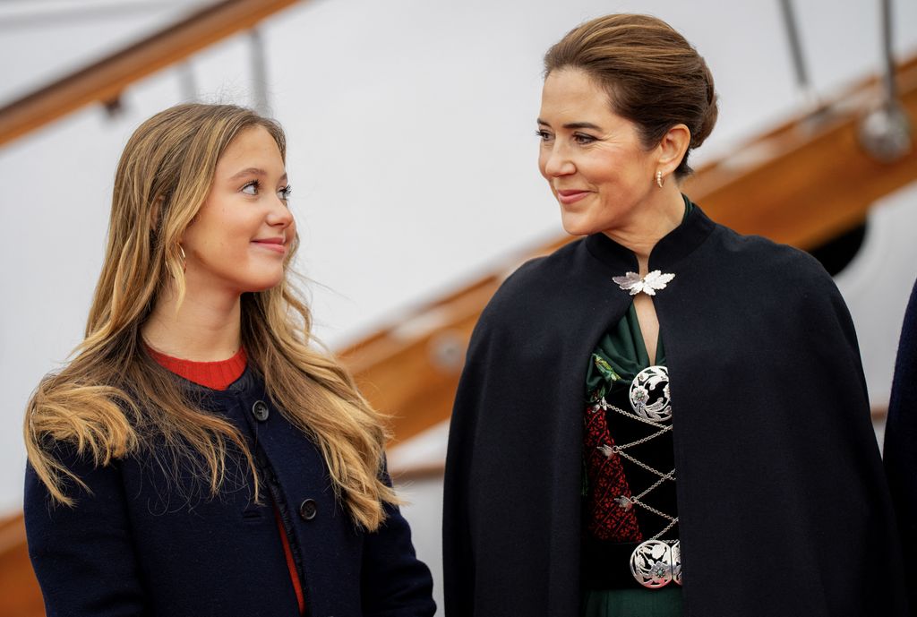 Denmark's Queen Mary and her daughter Princess Josephine (L) smile at each other upon their arrival with the Royal Yacht  in Torshavn