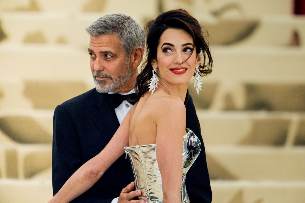 George Clooney and lawyer Amal Clooney enter the Heavenly Bodies: Fashion & The Catholic Imagination Costume Institute Gala at The Metropolitan Museum on May 07, 2018 in New York City.  (Photo by Ray Tamarra/GC Images)