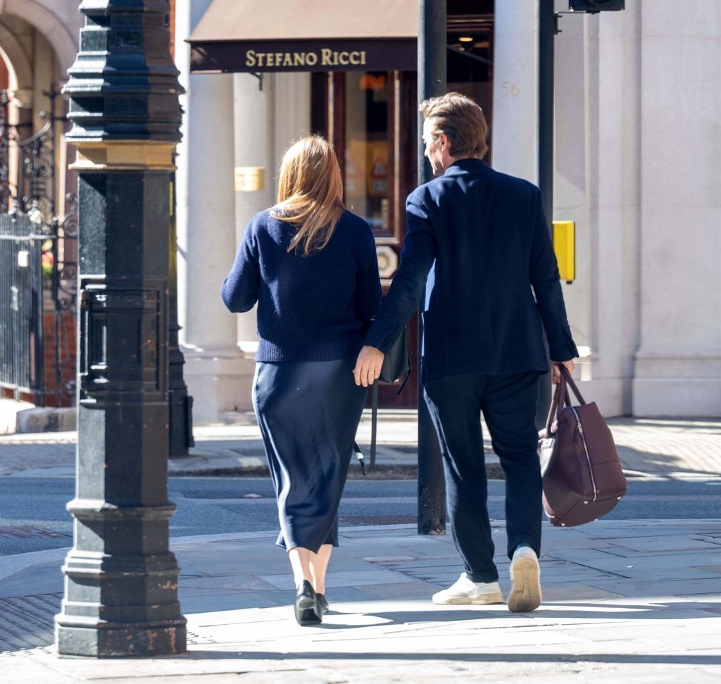 Princess Beatrice wearing navy satin skirt with blue knit alongside Edoardo Mapelli Mozzi 