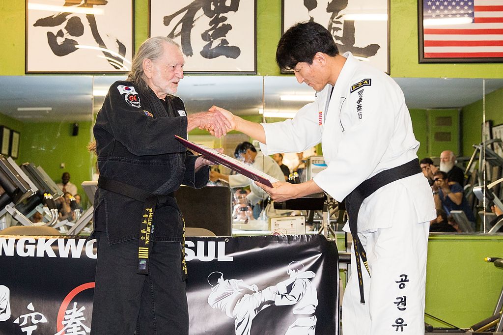 AUSTIN, TX - APRIL 28:  Musician Willie Nelson is presented with his 5th Degree Black Belt in the art of Gong Kwon Yu Sul by Grand Master Sam Um (R) at his studio Master Martial Arts on April 28, 2014 in Austin, Texas.  (Photo by Rick Kern/WireImage)