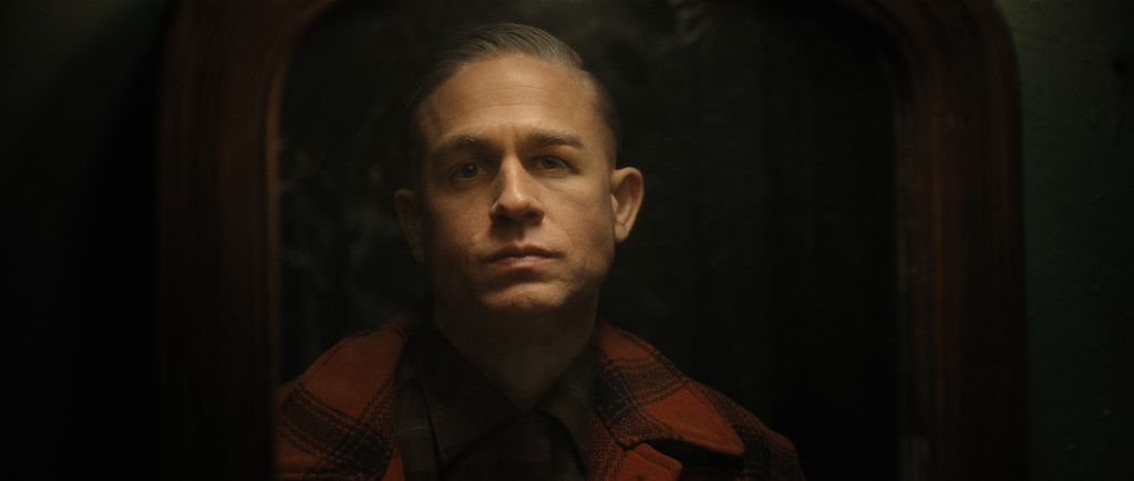 close-up of man in red and black jacket in dimly lit room
