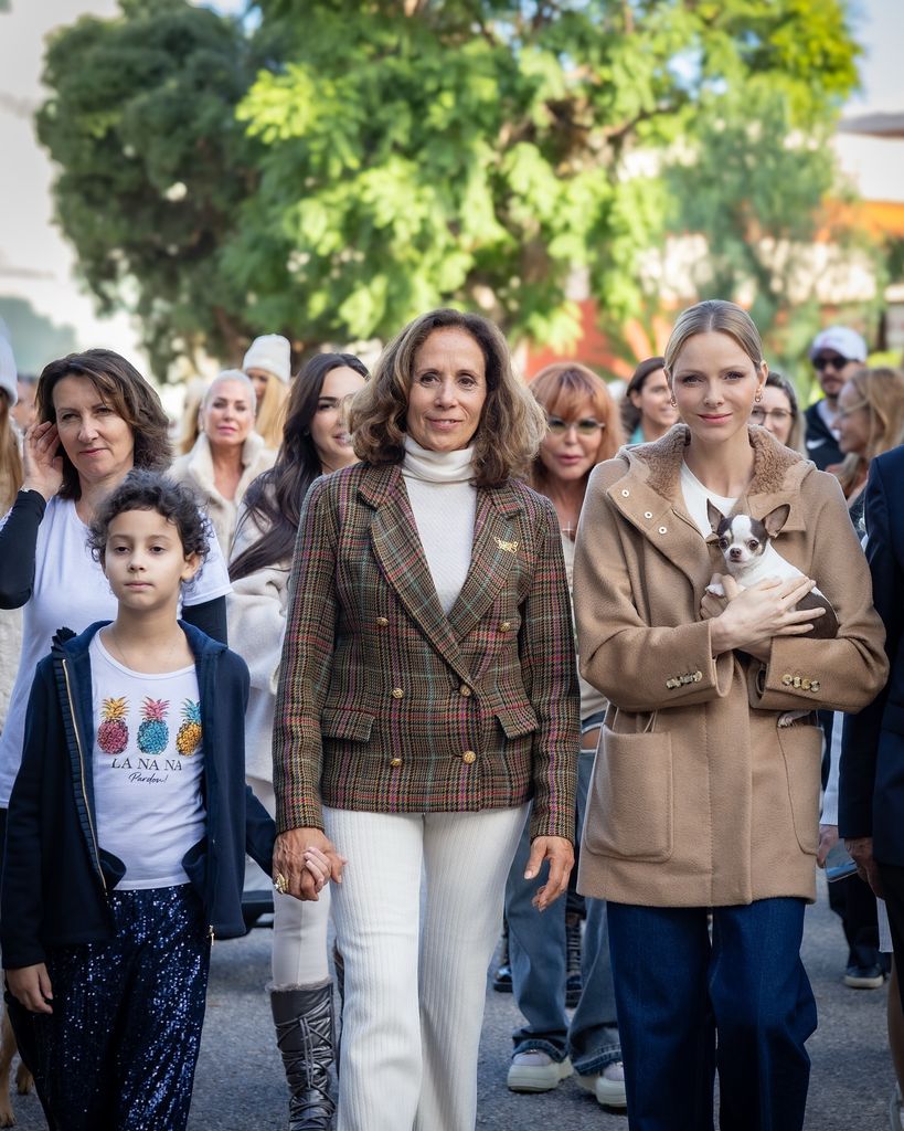 Charlene menggendong anjing bermantel yang memimpin jalan-jalan anjing