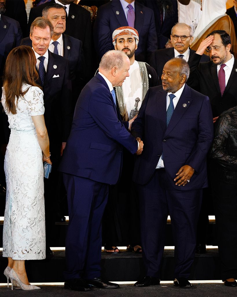 Queen Mary looking behind her to talk to group of men