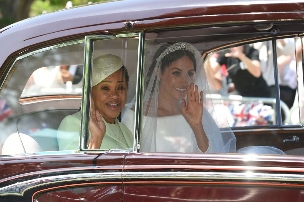 Meghan Markle waving in the car with her Doria Ragland arrive for her wedding ceremony