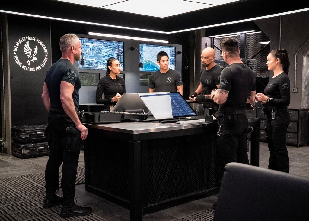 Jay Harrington as David Kay, Annie Ilonzeh as Devin Gamble, David Lim as Victor Tan, Shemar Moore as Daniel Harrelson, Niko Pepaj as Miguel Alfaro, and Anna Enger Ritch as Zoe Powell stand around the table in SWAT series finale