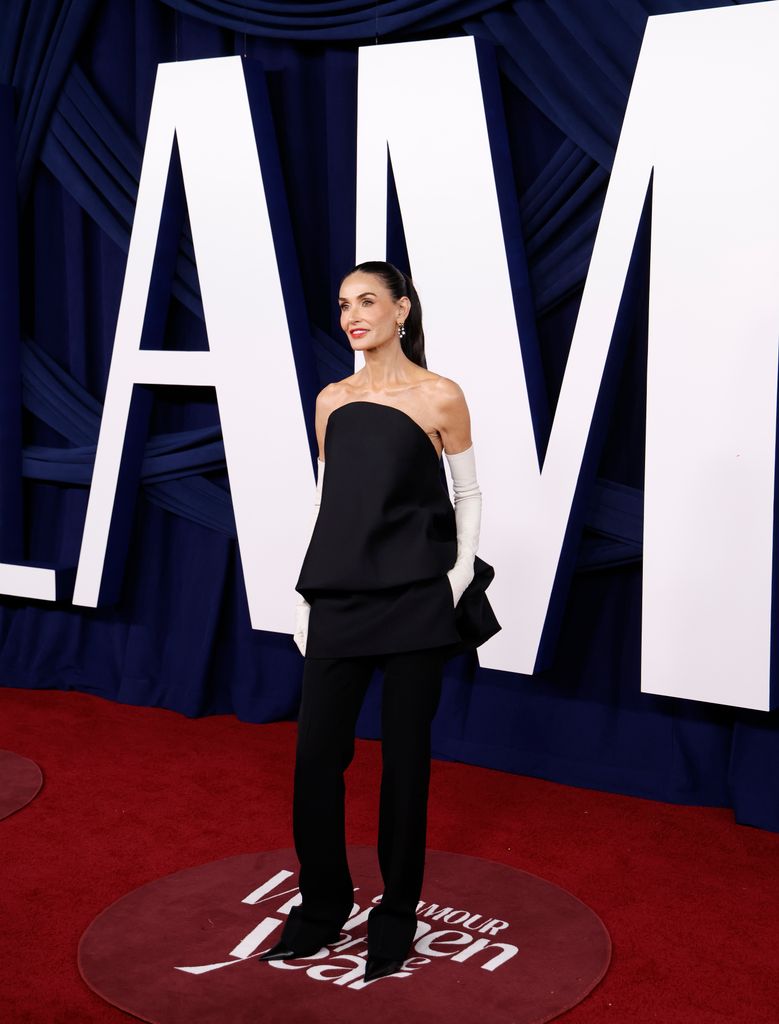 foto demi moore dengan rambut dikuncir dan mengenakan sarung tangan opera putih