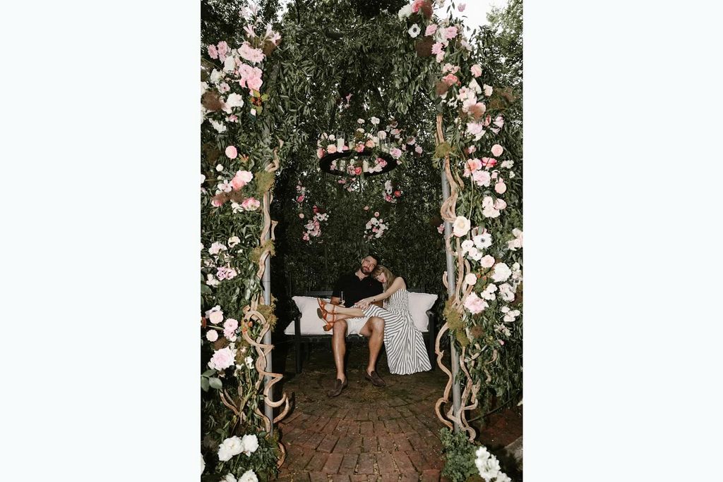 taylor swift sitting with leg over travis kelce in rose garden after engagement