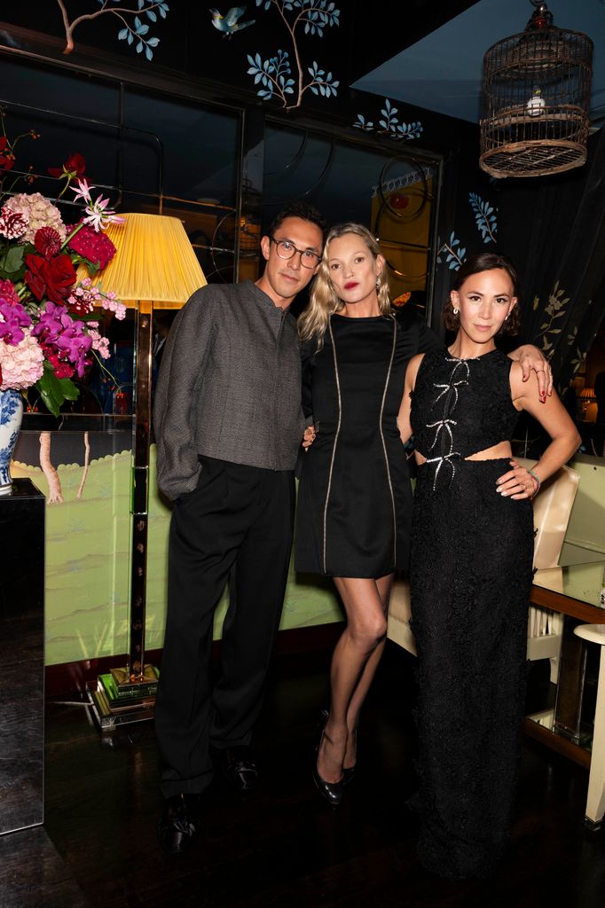 Kate Moss posing with friends wearing a black dress