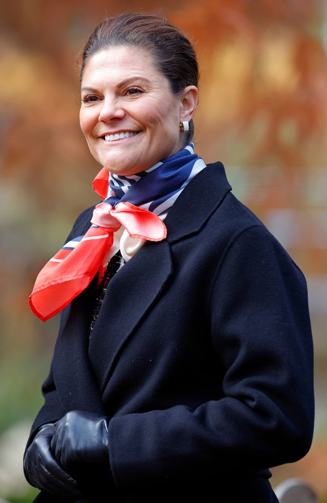 Crown Princess Victoria of Sweden in coat and red scarf