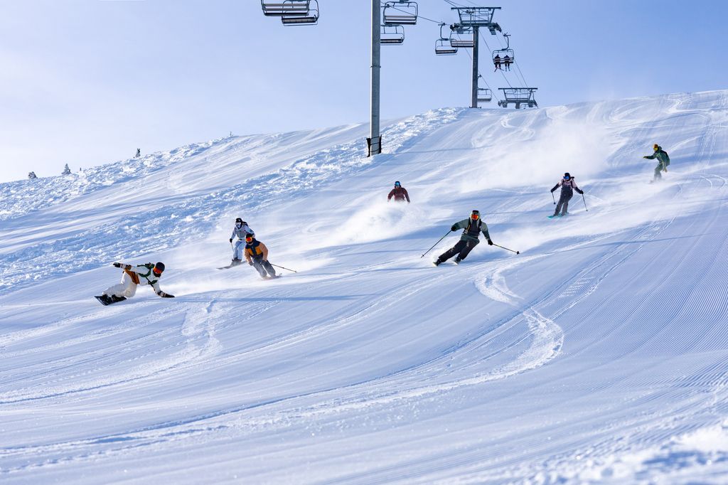 Skiers and snowboarders cruising down the snowy mountains