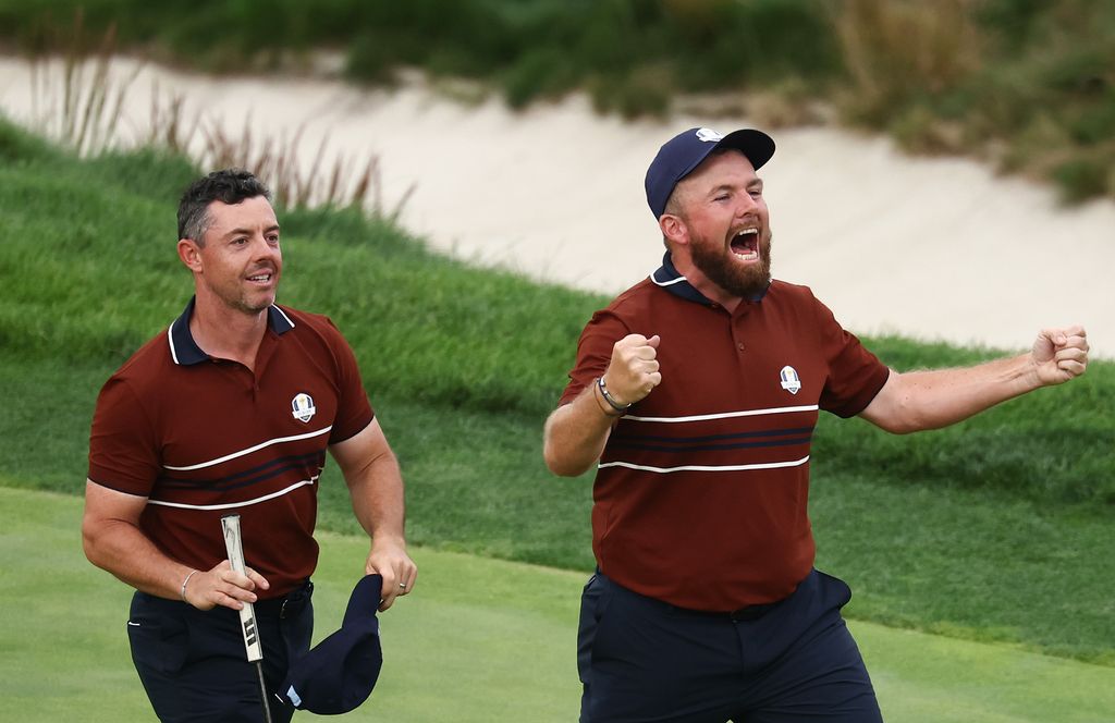 Rory McIlroy and Shane Lowry of Team Europe celebrate defeating Justin Thomas and Cameron Young of Team United States 2 Up on the 18th green during the Saturday afternoon four-balls matches of the 2025 Ryder Cup at Black Course at Bethpage State Park Golf Course on September 27, 2025 in Farmingdale, New York