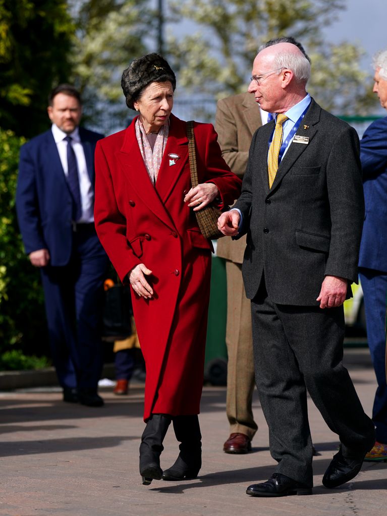 The Princess Royal in red coat talking to man
