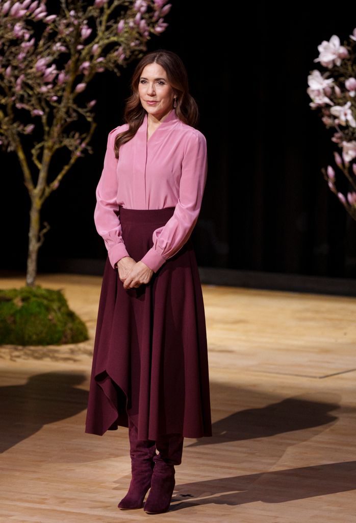 Queen Mary wearing pink blouse and burgundy skirt