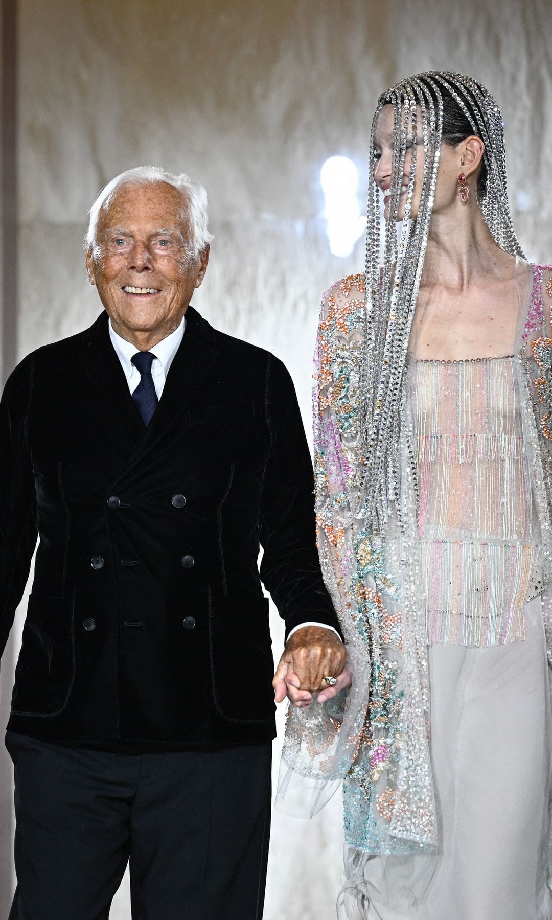Italian designer Giorgio Armani acknowledges the applause with Latvian model Agnes Zogla at the end of his presentation for Armani Prive during the Women's Haute-Couture Spring/Summer 2025 Fashion Week to mark its 20th anniversary, in Paris on January 28, 2025. 
