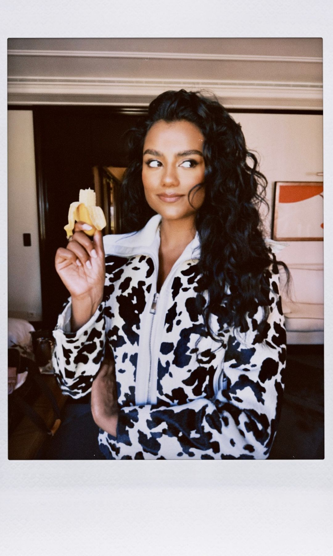 Simone Ashley poses for a picture in a cow print jacket 