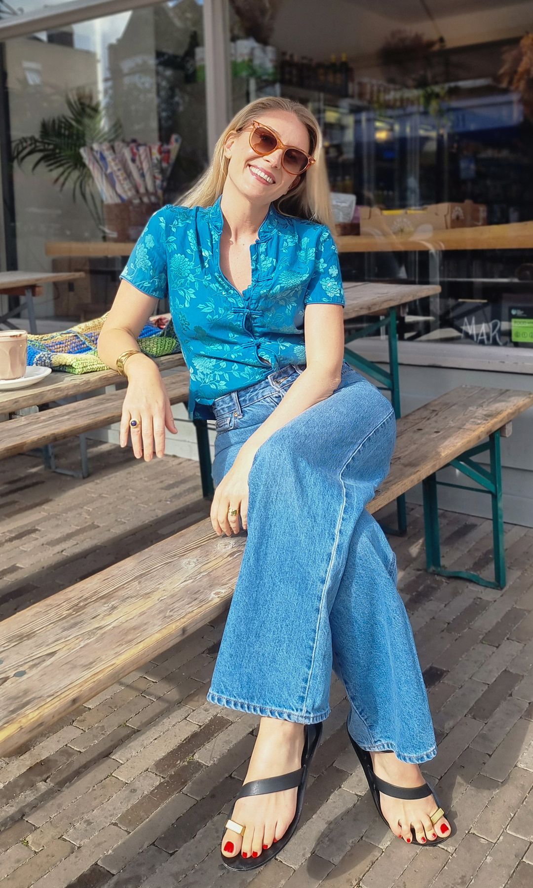 Aliya Wilkinson en chemise bleue et jean