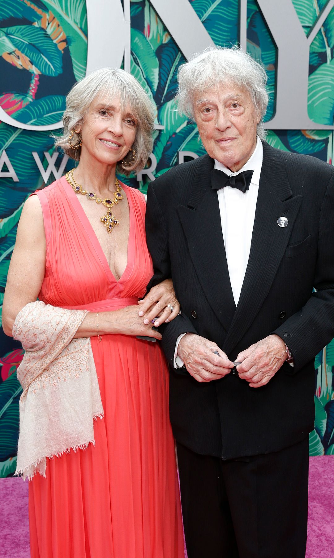 Sabrina Guinness in a red dress with husband Tom Stoppard in a tuxedo