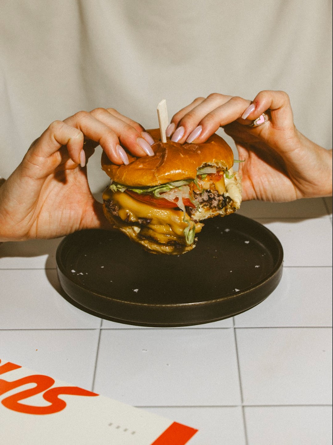 Two hands holding a burger