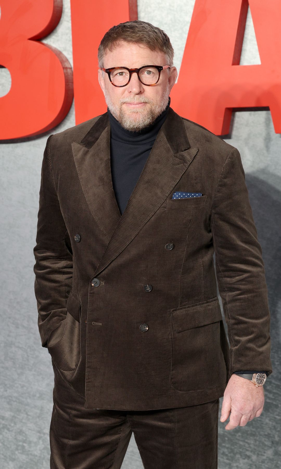 Guy Ritchie in a brown suit