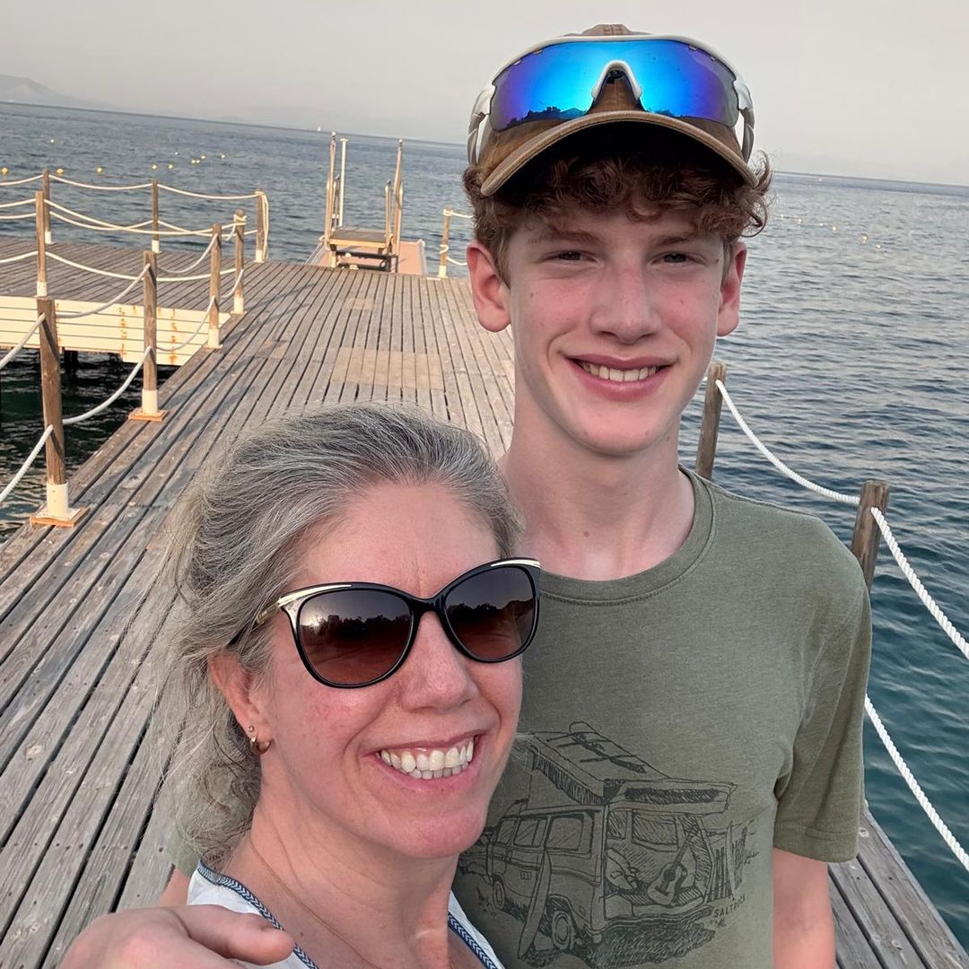a mum and teenage son standing on a jetty in Greece