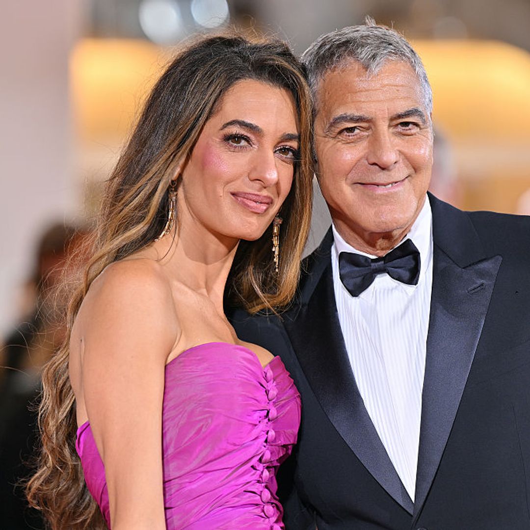 George Clooney and Amal Clooney (with her honey-toned locked and fuchsia dress) at the Venice International Film Festival 